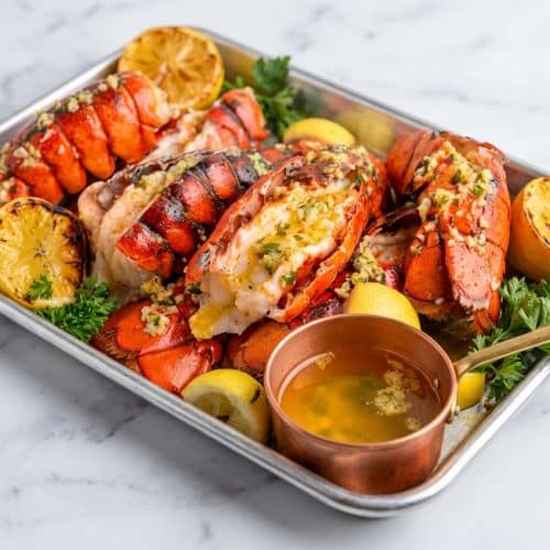 Broiled lobster tail recipe featuring a golden umami-rich miso-brown butter baste and fresh parsley.