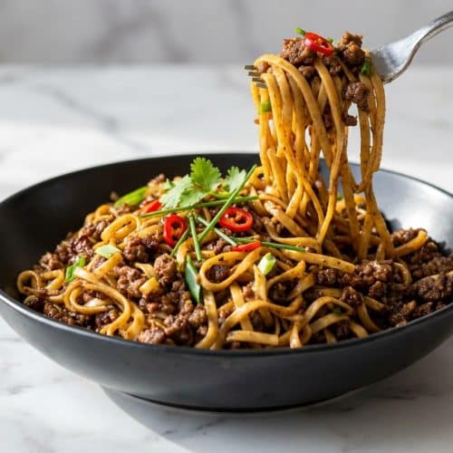Savory mongolian ground beef noodles with a bright rice vinegar balance and fresh green onion garnish.