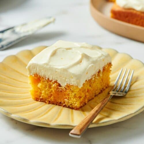 Orange creamsicle cake slice with orange blossom cream cheese whipped topping and fresh zest.