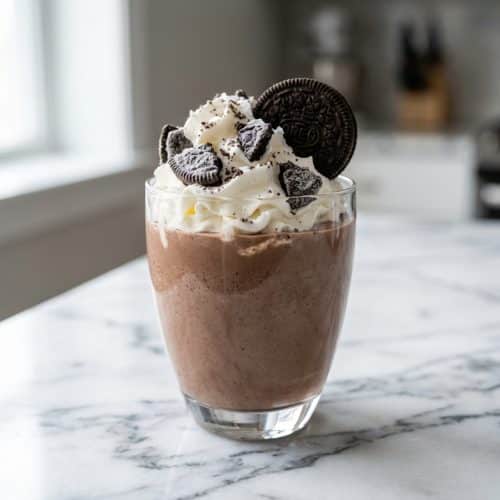 Thick oreo milkshake with whipped cream, featuring a rich texture from the frozen cookie and salt method.
