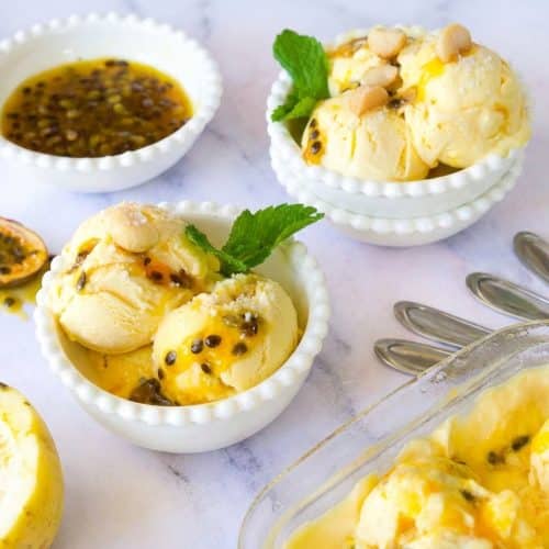 Scoops of Passion Fruit Ice Cream topped with toasted macadamia nuts, featuring a creamy, sea salt and rum-infused base.
