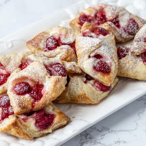 Golden Raspberry Cheese Danish with aromatic cardamom filling and a decorative fork-crimp double-seal.