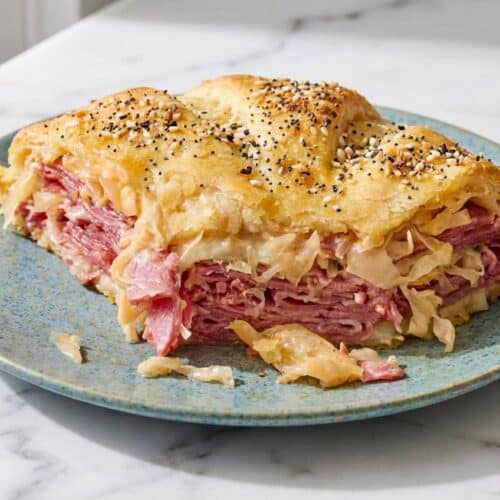 Golden reuben crescent bake topped with everything bagel seasoning and melted caraway-garlic butter.