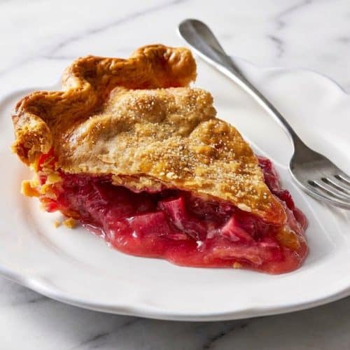Golden rhubarb pie with a lattice crust featuring ginger-infused sugar and browned butter accents.