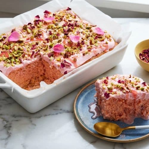 Slices of rose milk cake soaked in a double-rose cold infusion topped with whipped cream and dried petals.