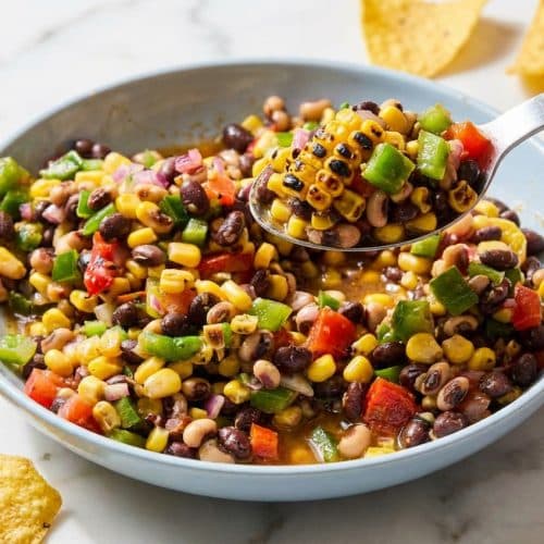 Cowboy Caviar Recipe featuring charred fire-roasted corn, black beans, and colorful veggies in a serving bowl.