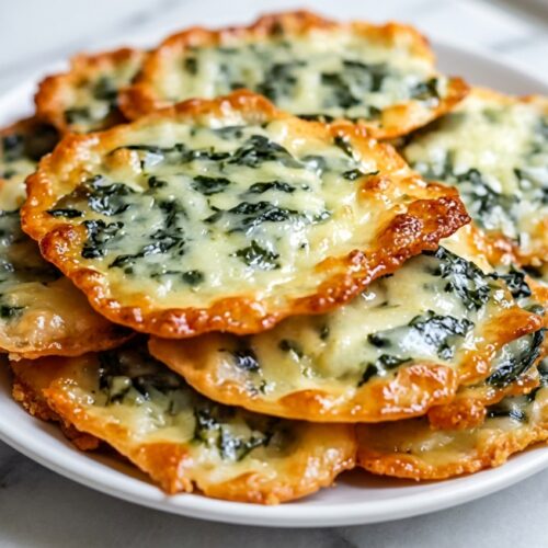 Golden spinach dip cheese crisps featuring a crispy Parmesan-panko crusted base on a serving platter.