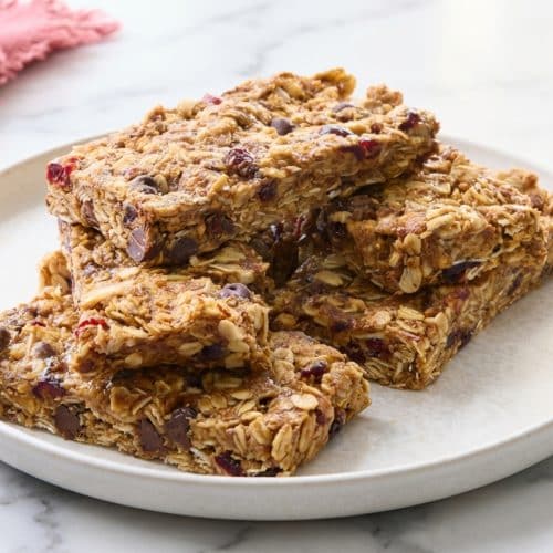 Stacked no bake granola bars showing golden toasted oats, mini chocolate chips, and a rich brown butter glaze.