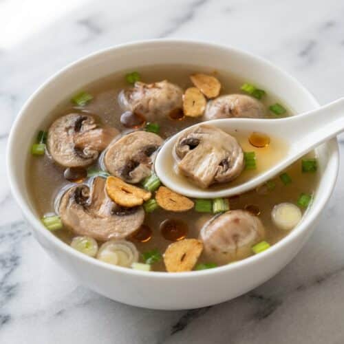 Bowl of Japanese clear soup with sliced mushrooms and scallions, showcasing a deep golden toasted umami infusion.
