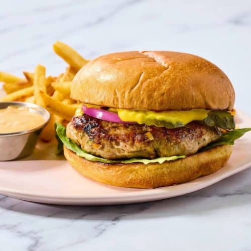 Juicy Turkey Burgers with a golden seared crust demonstrating the mayo-binder technique on a toasted bun with fresh lettuce