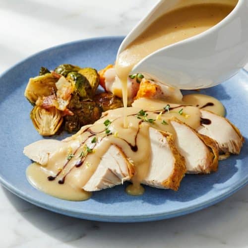 Velvety turkey gravy poured from a boat, showing the rich color of the umami-acid balance finish.