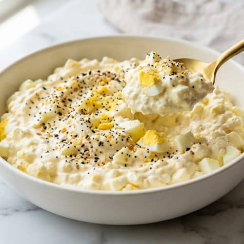 A creamy bowl of whipped cottage cheese egg salad topped with a generous sprinkle of Everything Bagel Crunch and fresh chives.