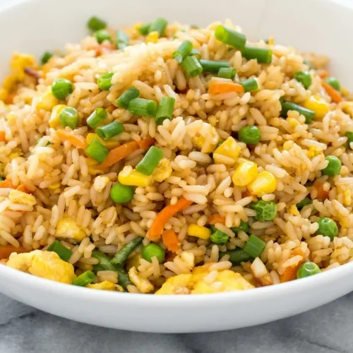 Air fryer fried rice recipe topped with crunchy toasted cashews and spicy garlic chili crisp oil.