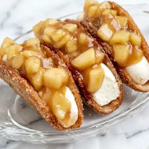 Crispy Apple Cheesecake Tacos with salted caramel smeared inside the cinnamon-sugar shells topped with flaky sea salt.