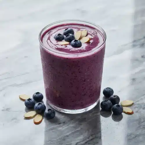 Creamy blueberry almond milk smoothie topped with fresh lemon zest and a hint of almond extract.