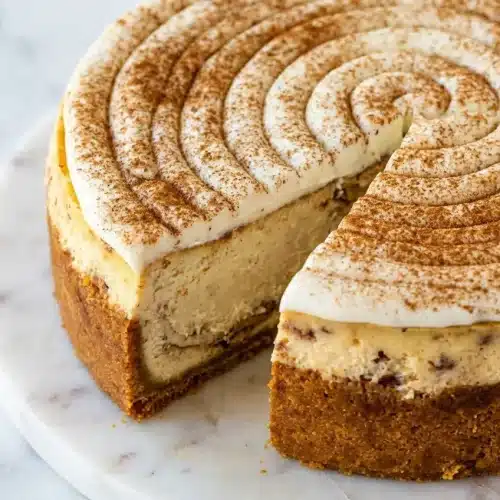Cinnamon roll cheesecake featuring a nutty browned butter graham cracker crust and fragrant cardamom spiced swirls.