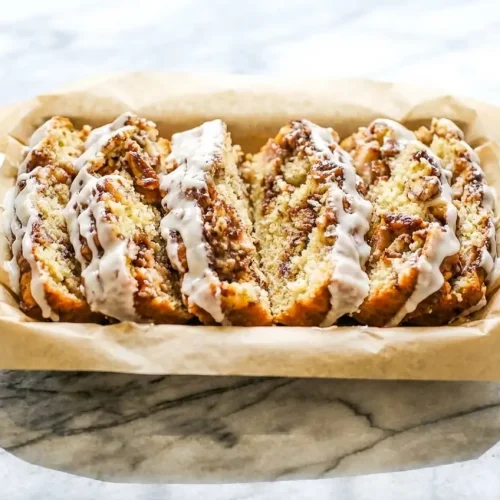 Sliced Famous Apple Fritter Bread drizzled with a rich brown butter and salted maple glaze.