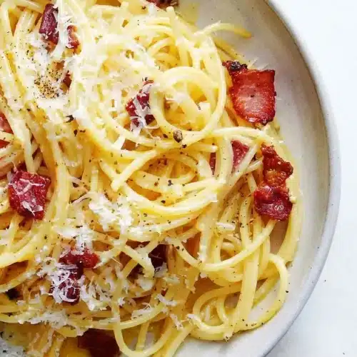 Creamy pasta carbonara with crispy guanciale, coated in a glossy emulsion made by tempering hot rendered fat into the eggs.