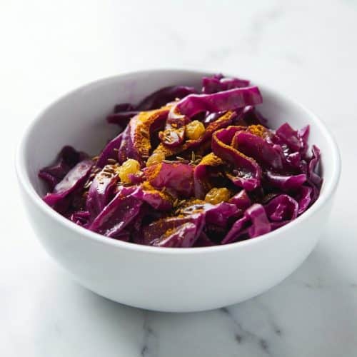 A mason jar filled with a fermented cabbage recipe, featuring a weighted spice infusion and bubbling brine for perfect crispness.