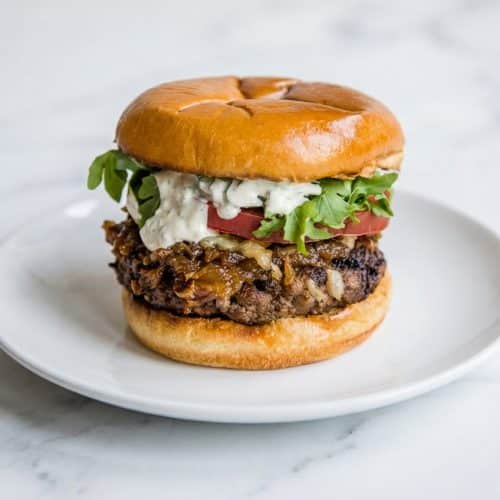 French onion burgers topped with cognac and balsamic glazed onions and melted Gruyère cheese on a toasted brioche bun.