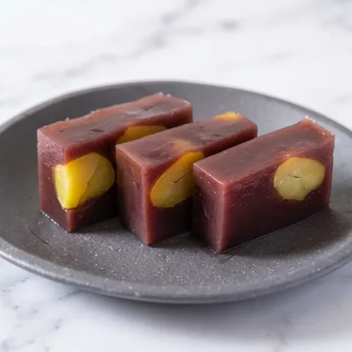 Chilled Hojicha-infused Mizu Yokan jelly recipe topped with flaky sea salt, served on a dark ceramic plate.