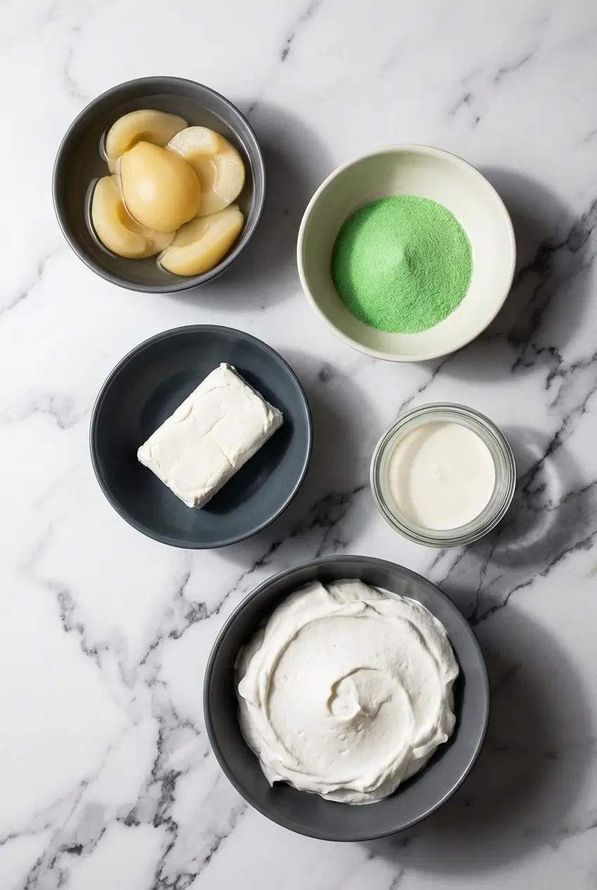Raw ingredients for Retro Sea Foam Salad Recipe including lime flavored Jell-O mix, canned pear halves, and cream cheese.