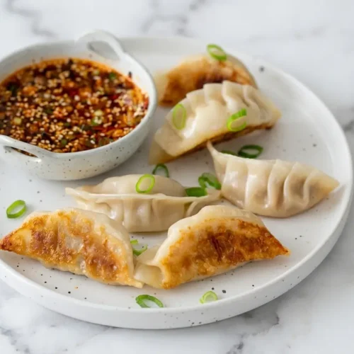 Steaming hot cabbage dumplings broken open to reveal a rich, juicy gelatinized broth aspic melting inside the savory pork.