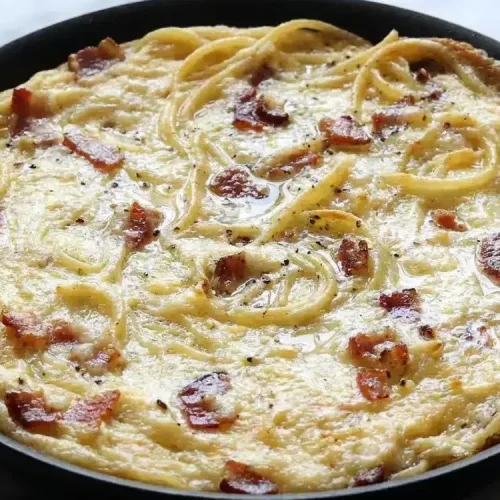 Leftover pasta frittata with a golden, crispy Parmesan-Panko brulée crust in a cast iron skillet.