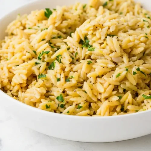 Lemon Orzo Recipe finished risotto-style with toasted golden pasta, cold butter, and grated Parmesan in a serving bowl.