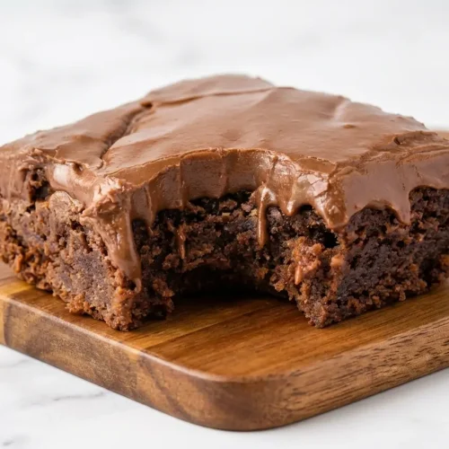 Fudgy Lunch Lady Brownies with glossy chocolate frosting, browned butter, and a sprinkle of flaky sea salt.