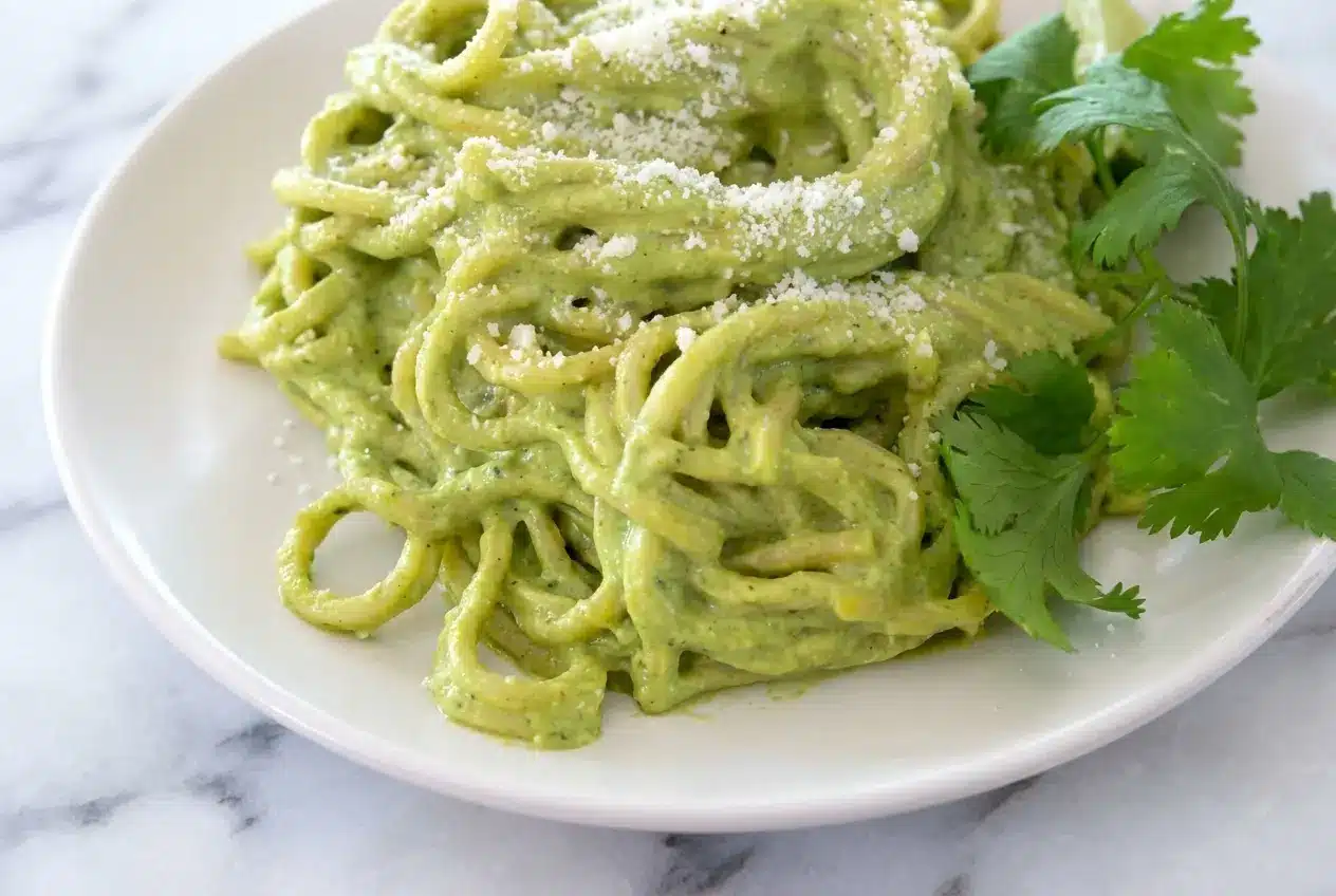 Bowl of Mexican green spaghetti recipe with roasted garlic and poblano cream sauce, finished with a squeeze of fresh lime.