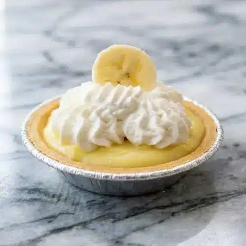 Mini banana cream pies featuring a malted milk chocolate barrier inside a crisp graham cracker crust.