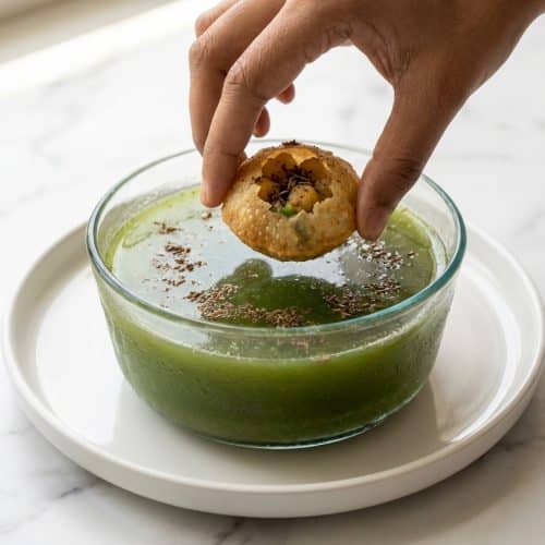 Crispy puris for this Pani Puri Recipe filled with ragda alongside chilled mint water infused with roasted bhuna jeera.