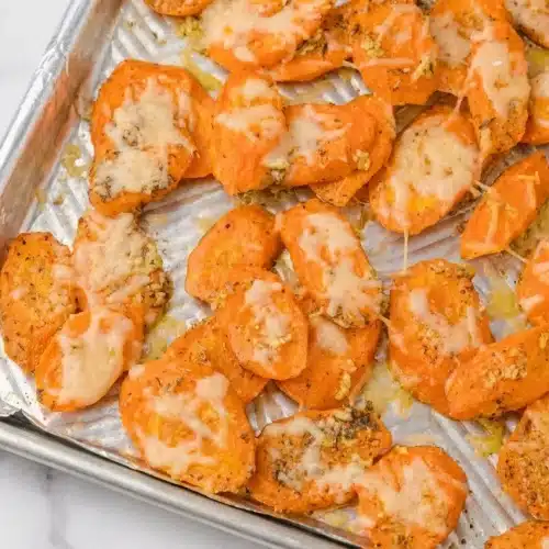 Parmesan Garlic Roasted Carrots coated in rich browned butter and fresh lemon juice, served on a rustic platter.