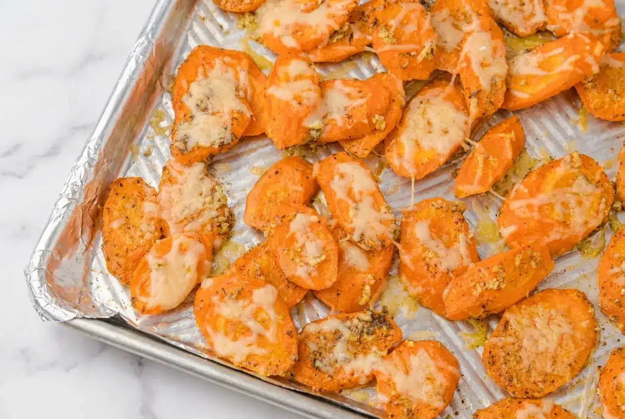 Parmesan Garlic Roasted Carrots coated in rich browned butter and fresh lemon juice, served on a rustic platter.