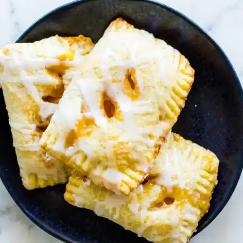 Golden Peach Hand Pies with a thyme-infused brown butter filling and flaky, sugar-dusted pastry crust.