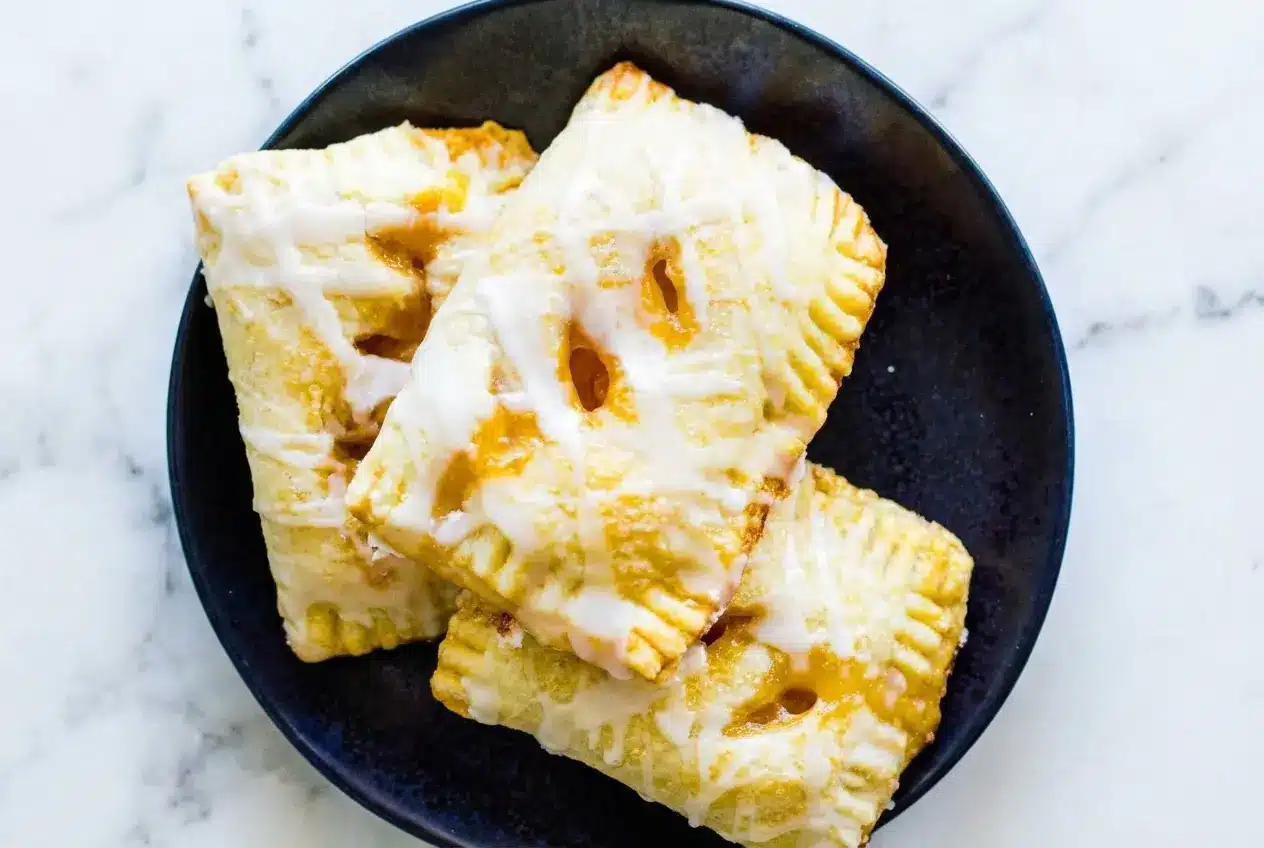 Golden Peach Hand Pies with a thyme-infused brown butter filling and flaky, sugar-dusted pastry crust.