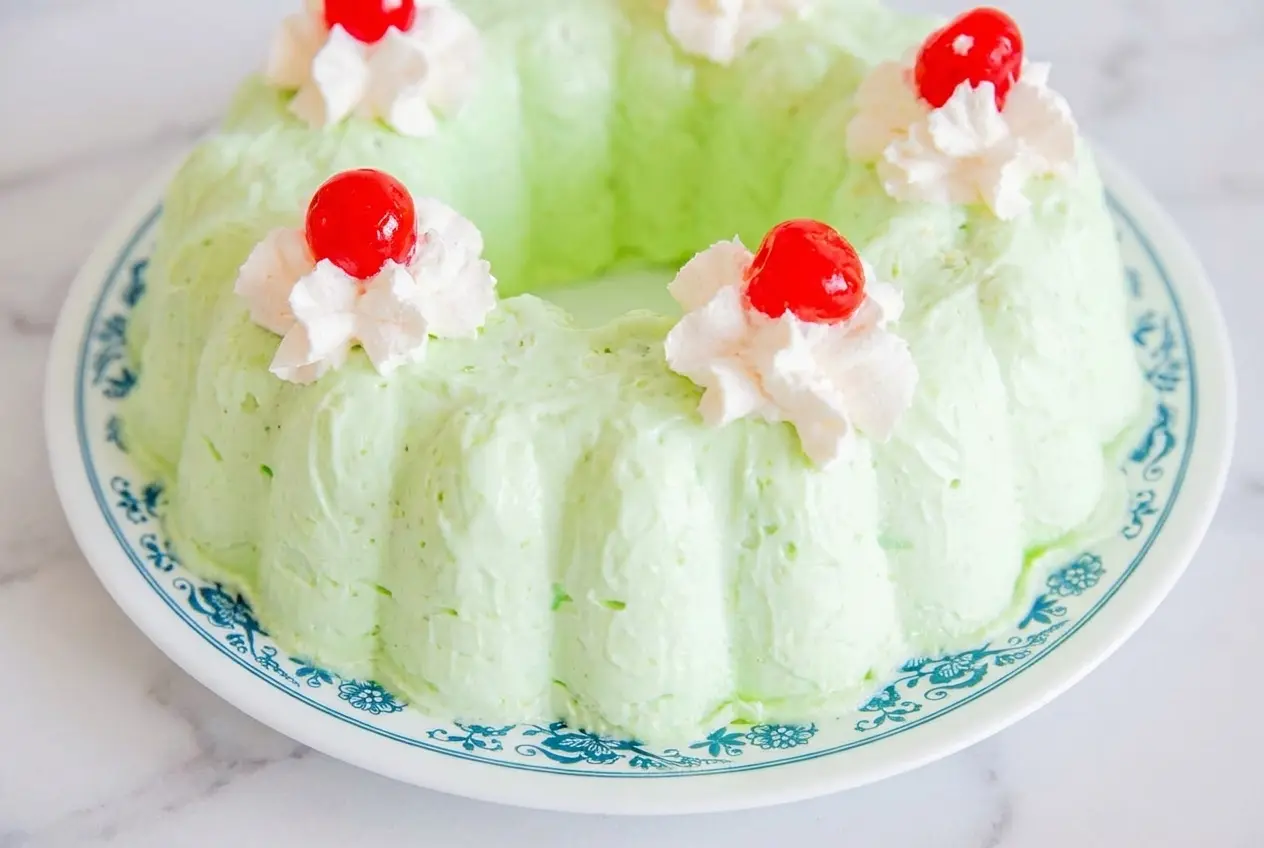 A slice of Retro Sea Foam Salad Recipe featuring toasted chopped pecans, cream cheese with vanilla, and mashed pears in a mold.