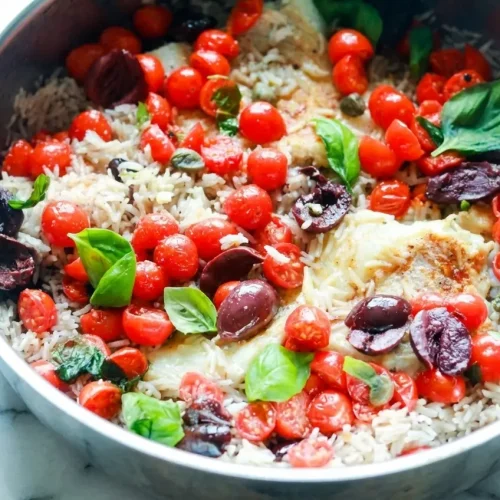 Golden saffron broth and white wine deglaze flavor this flaky rice with fish recipe, garnished with Kalamata olives and capers.