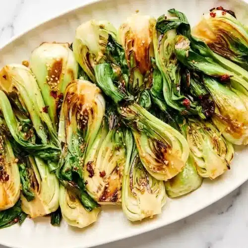 Caramelized baby greens seasoned with black vinegar and white pepper for a savory sauteed bok choy recipe.