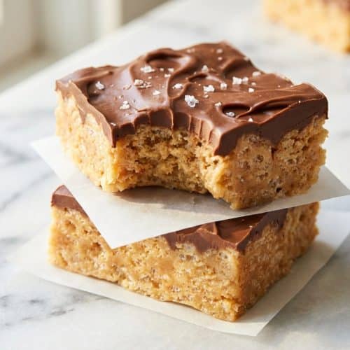 A platter of neatly cut Scotcharoos recipe bars, with a rich chocolate-butterscotch topping finished with a sprinkle of flaky sea salt.
