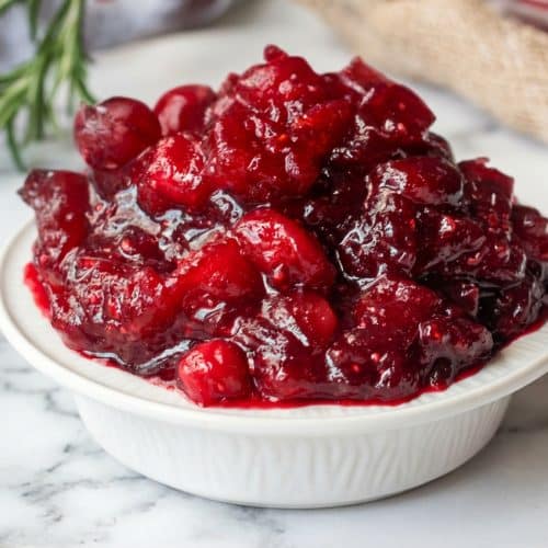 Bowl of vibrant cranberry relish recipe featuring chopped fresh cranberries mixed with cooked puree for a unique texture-bridge effect