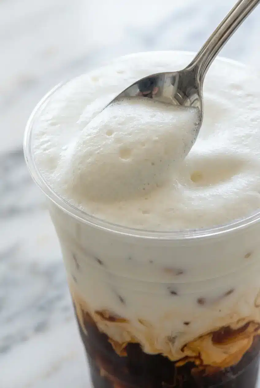 Thick micro-foam from a protein cold foam recipe, created by dry-shaking before using a handheld milk frother.