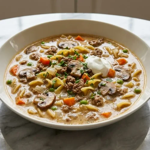 A rich bowl of Beef Stroganoff Soup with tender sirloin steak and noodles, featuring an extra creamy broth from a mushroom umami bomb.