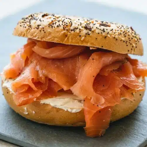 A whole fillet of homemade cold smoked salmon, thinly sliced to reveal its silky, translucent texture.