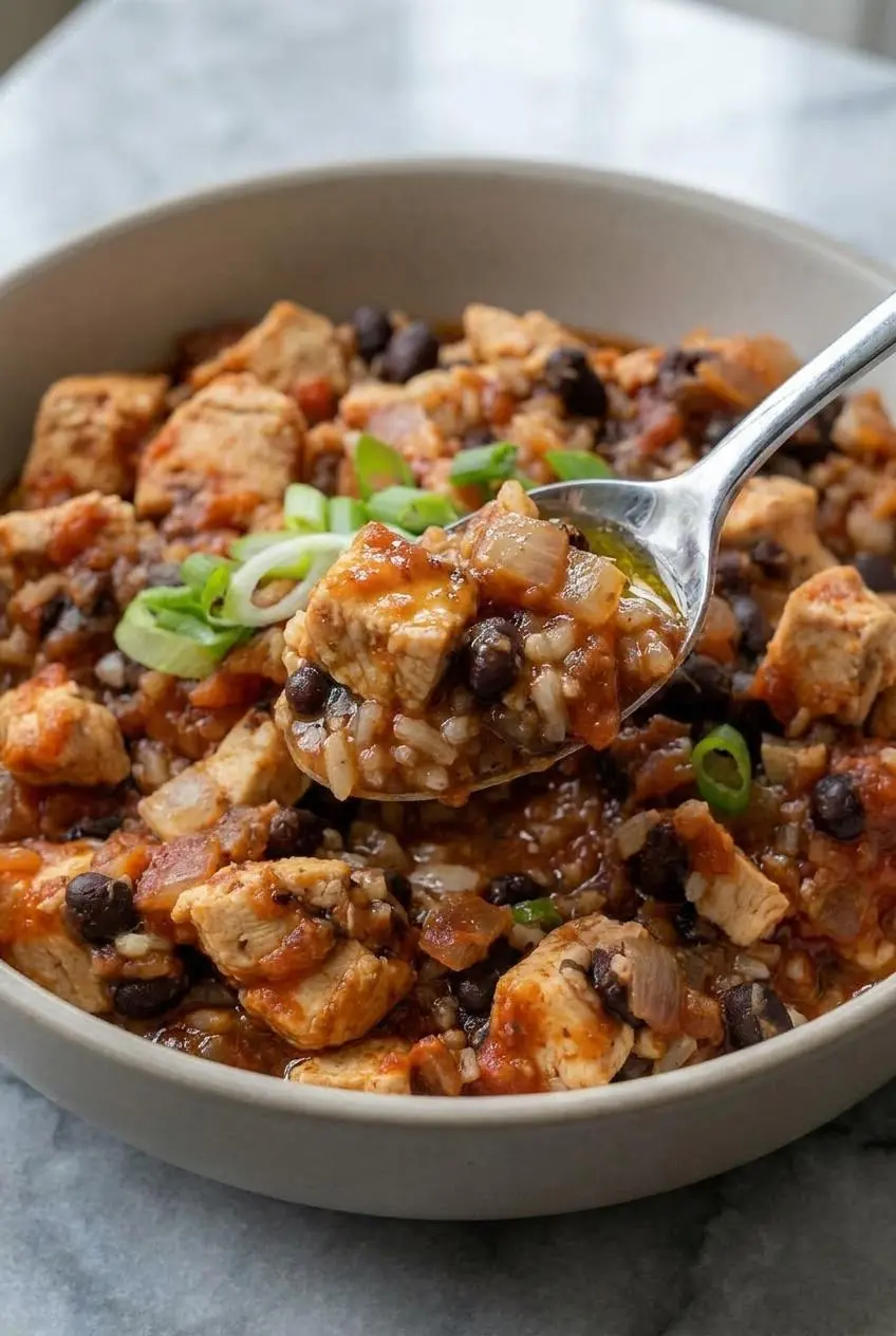 A close-up view of the high protein chicken burrito bowl, highlighting the creamy texture of the smoky chipotle cottage cheese sauce drizzled over the top.