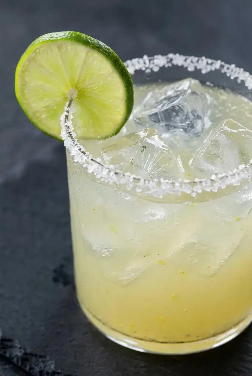 A close-up of a perfectly chilled virgin margarita, showing the texture of the salt crystals on the rim and condensation on the glass.