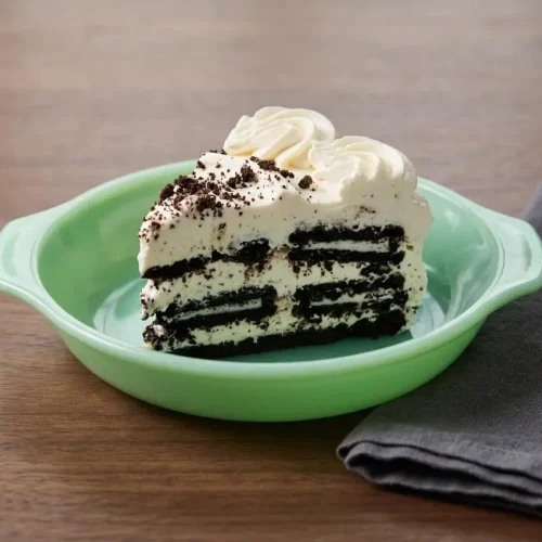 Sliced cookies and cream icebox cake with rich layers of softened chocolate sandwich cookies and fluffy whipped cream.