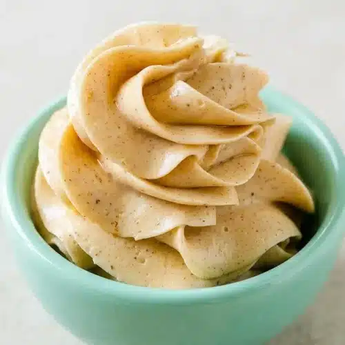 A white bowl filled with creamy, fluffy honey butter made with an easy recipe, ready for spreading on bread.