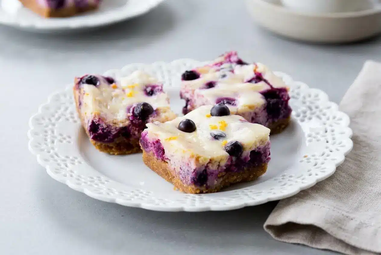 Creamy lemon blueberry cheesecake bars with a golden graham cracker crust and juicy baked blueberries.
